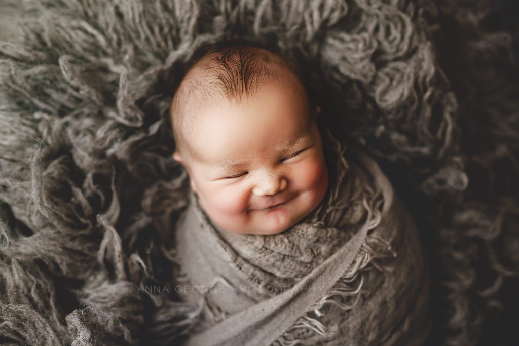 newborn boy smiling in his sleep