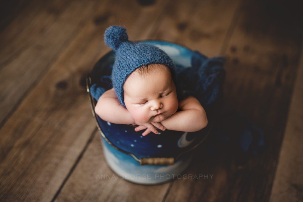 newborn boy in bucket by Anna George Photography
